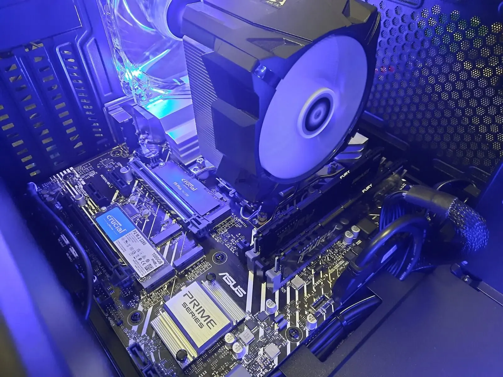 Scheda madre ASUS con SSD M.2 e dissipatore, illuminata di blu