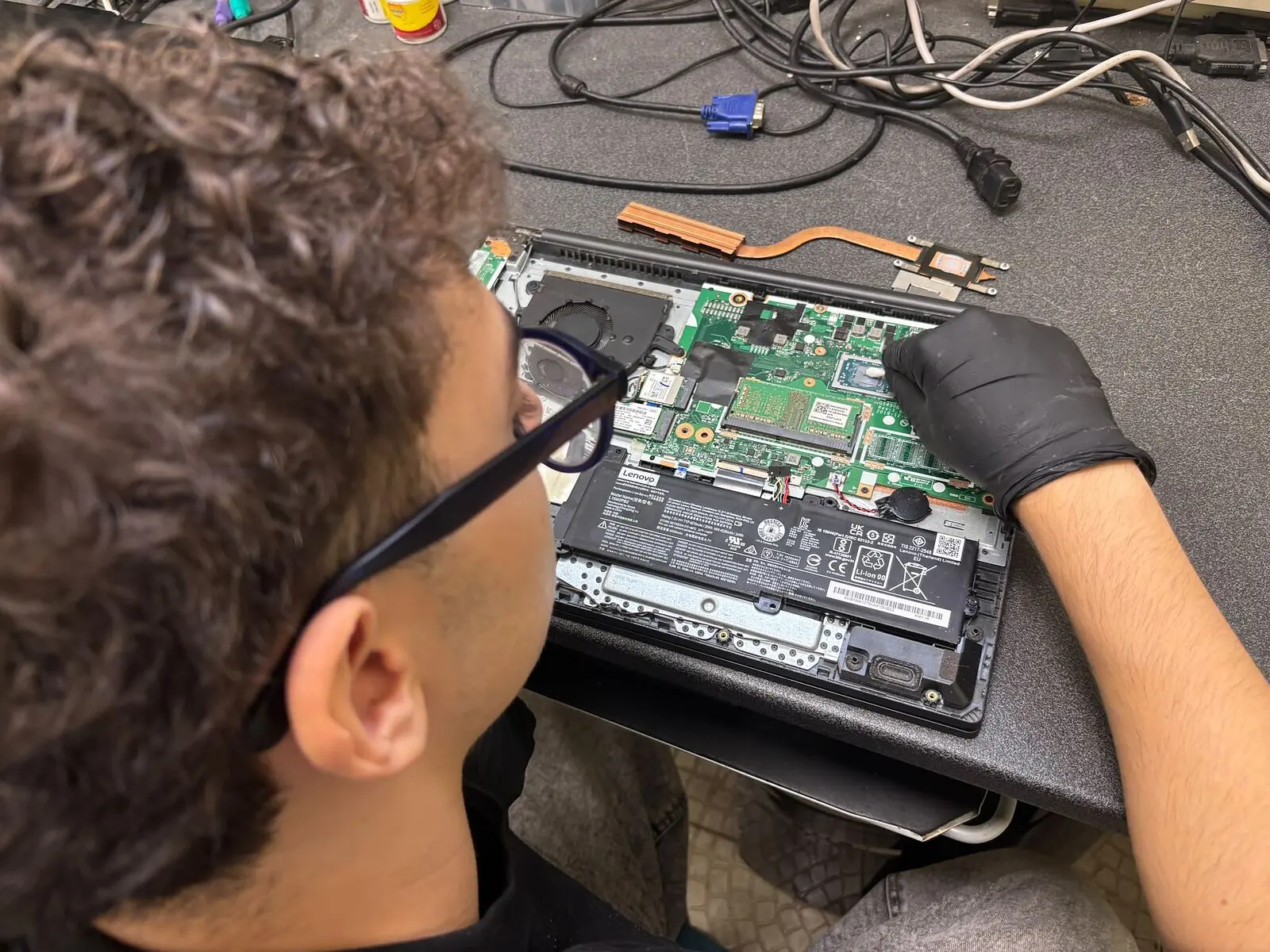 Tecnico al lavoro su un notebook Lenovo aperto